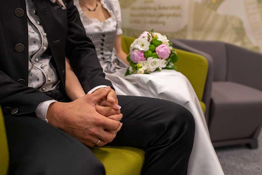 Brautpaar hält Hände bei der Trauung.
