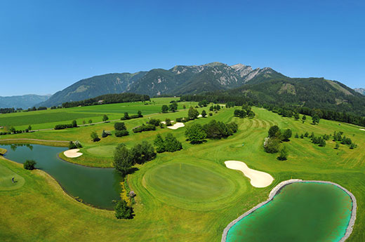 Blick von oben auf den wundervollen Golflatz mit herrlichem Bergpanorama