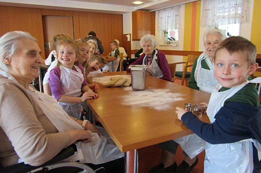 Kinder mit Senioren beim Backen